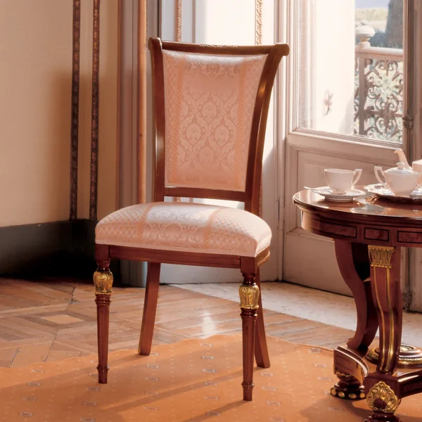 Elegant handmade Senator chair with embroidered upholstery, beside an elegant table in a luxury interior.