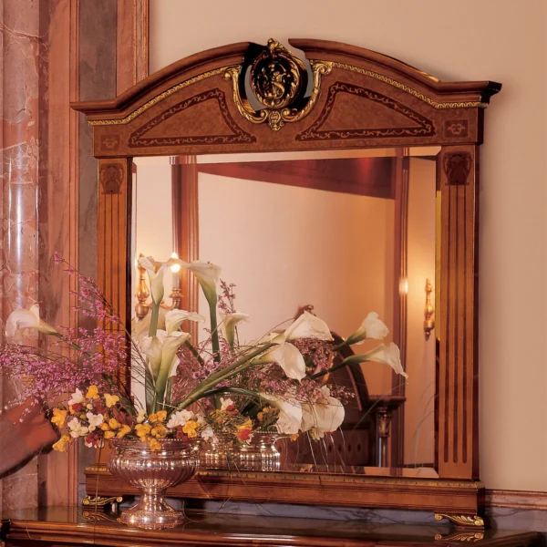 Elegant Senator mirror with intricate carvings, reflecting a floral arrangement, in a luxury villa interior.